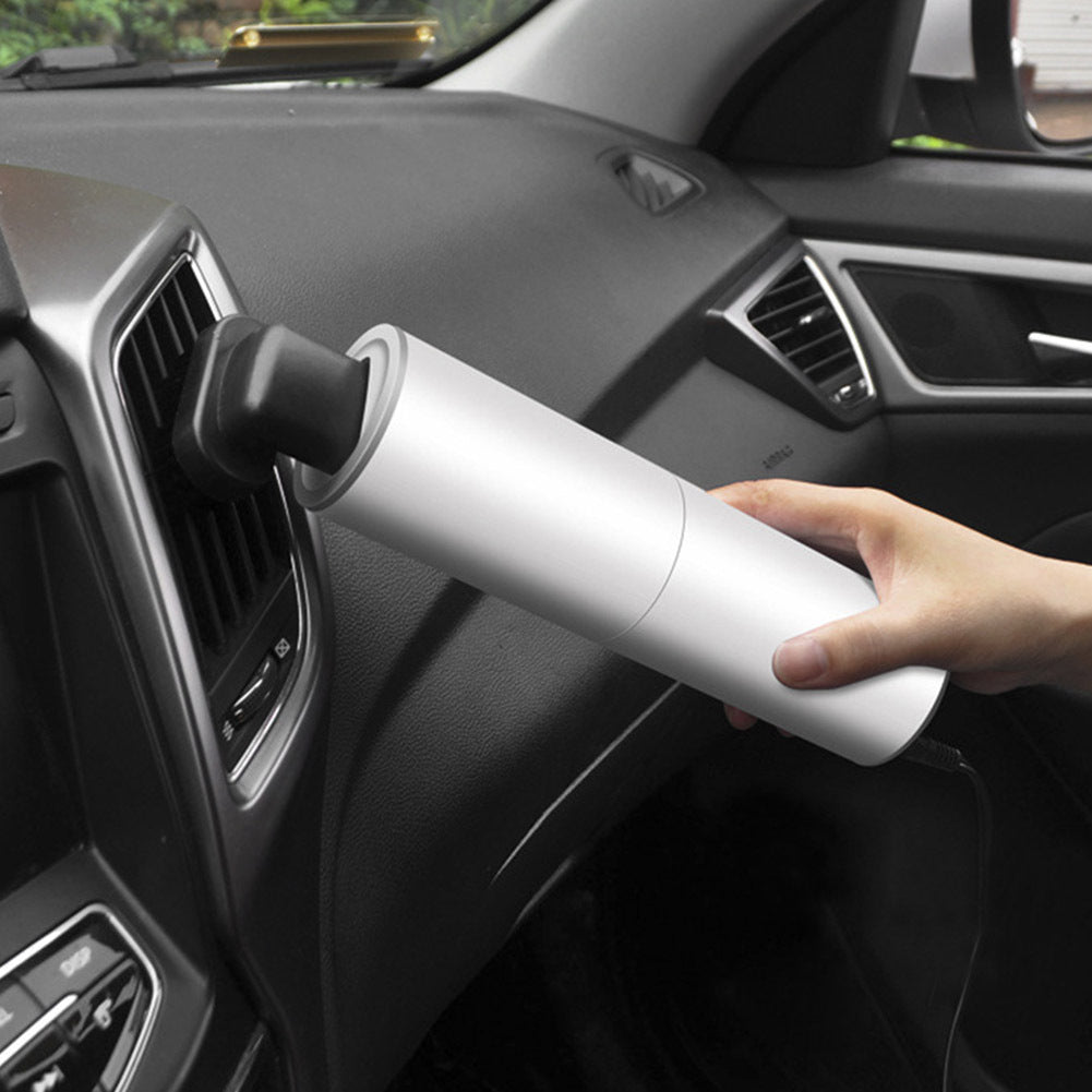Shopi Vella portable car vacuum cleaner in silver being used to clean car dashboard vents