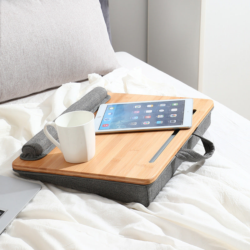 Shopi Vella portable computer desk for home with bamboo top and gray fabric base on bed holding tablet and coffee mug