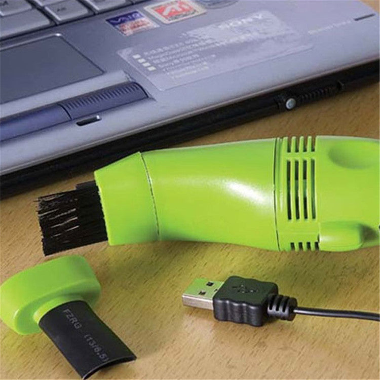 Shopi Vella portable computer keyboard brush in green with USB cable and brush cap next to laptop