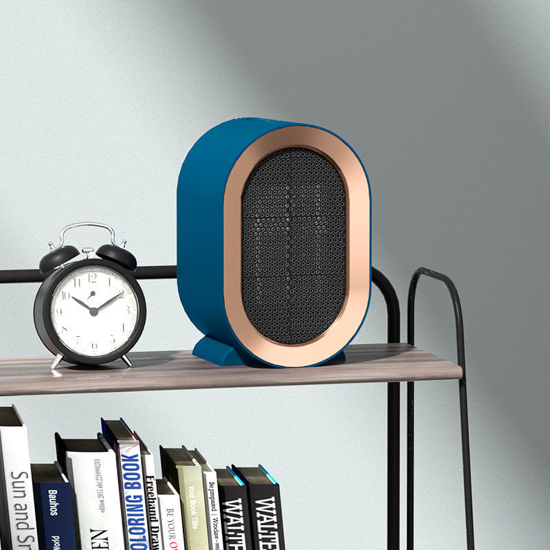 Shopi Vella portable desktop electric heater in blue and copper on a wooden shelf next to a black alarm clock