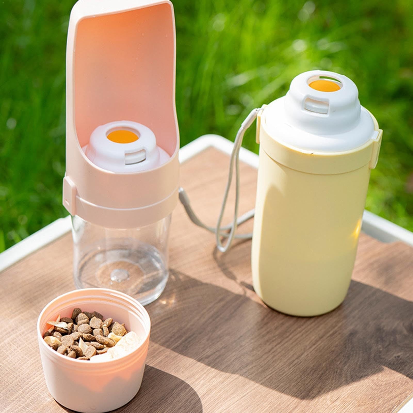 Shopi Vella portable dog water bottle in yellow with attached bowl and food container on wooden table
