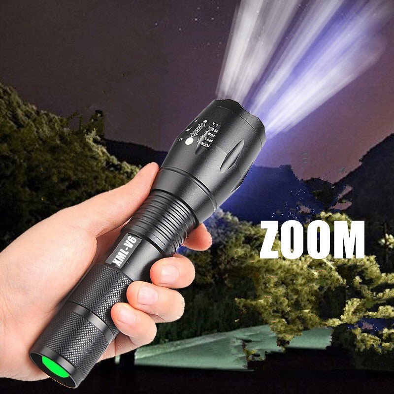 Shopi Vella portable mini LED flashlight held in hand with zoom focus beam shining at night