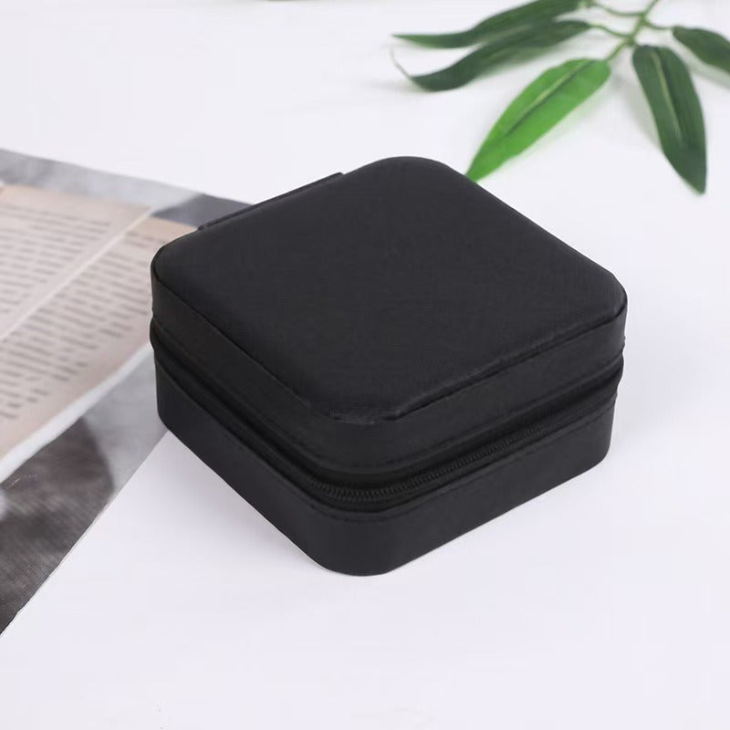 Black compact portable travel jewelry box with zipper closure by Shopi Vella
