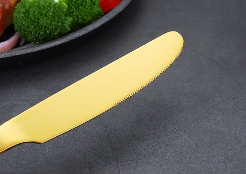 Gold serrated knife from Shopi Vella set with premium dinnerware for entertaining on dark surface