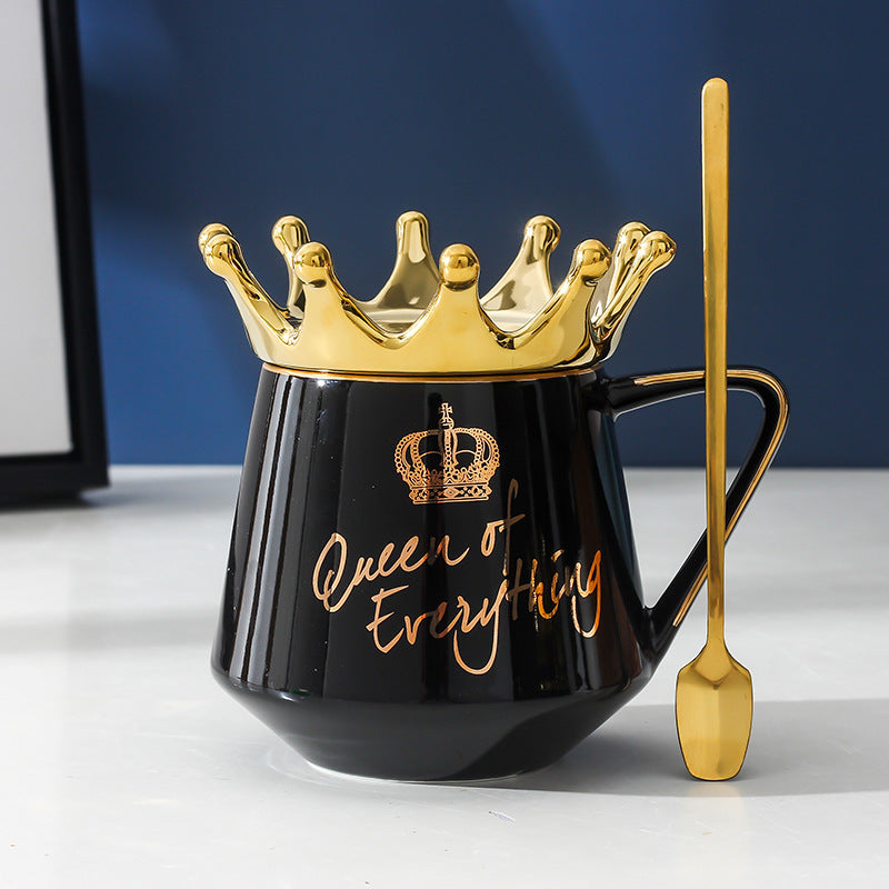 Shopi Vella queen mug with gold crown design and matching gold spoon on white surface