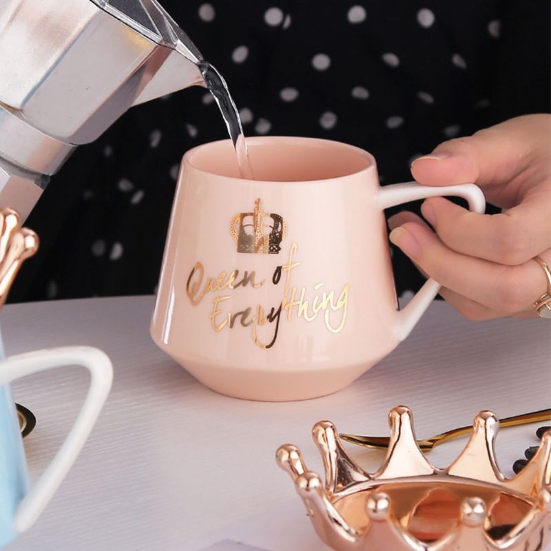 Shopi Vella queen mug with gold crown and gold lettering being filled with hot water