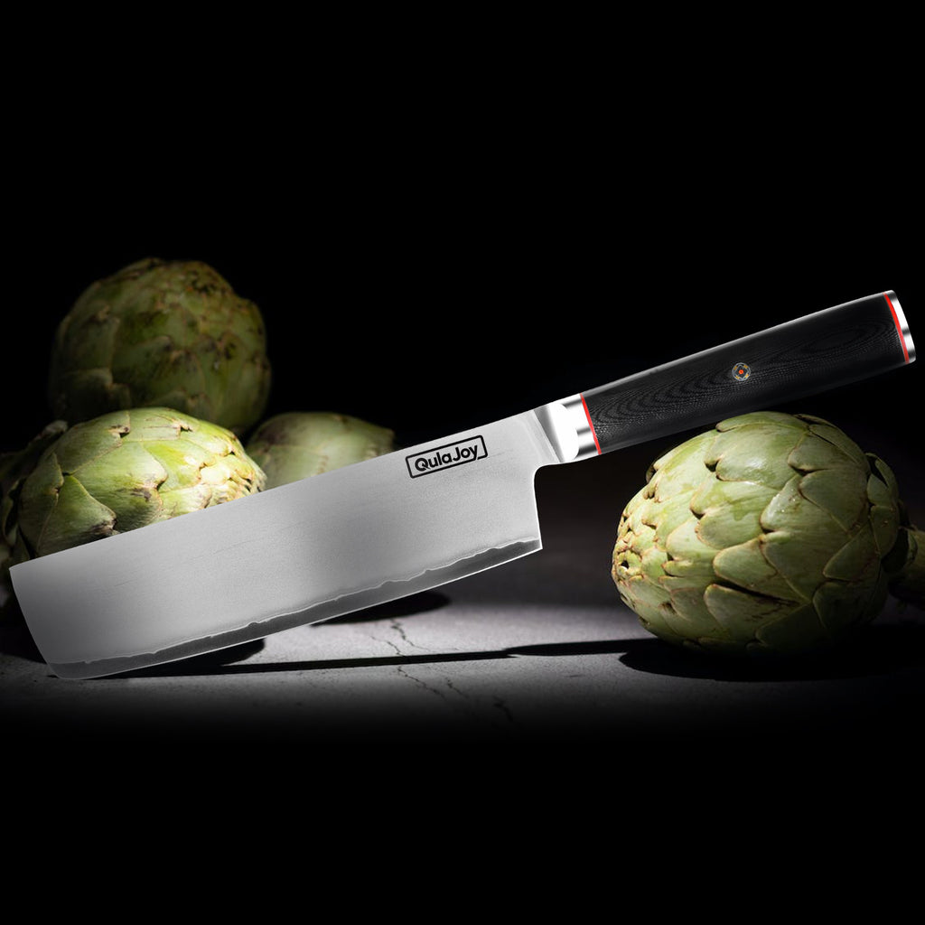 Shopi Vella 10Cr15MoV steel slicing knife with black handle beside fresh artichokes