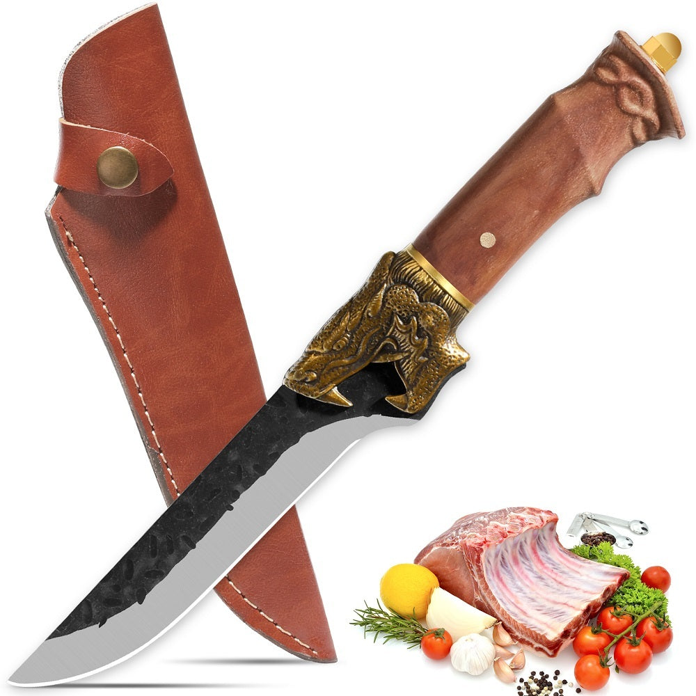 Dragon head camping knife with wooden handle and leather sheath next to raw meat and vegetables
