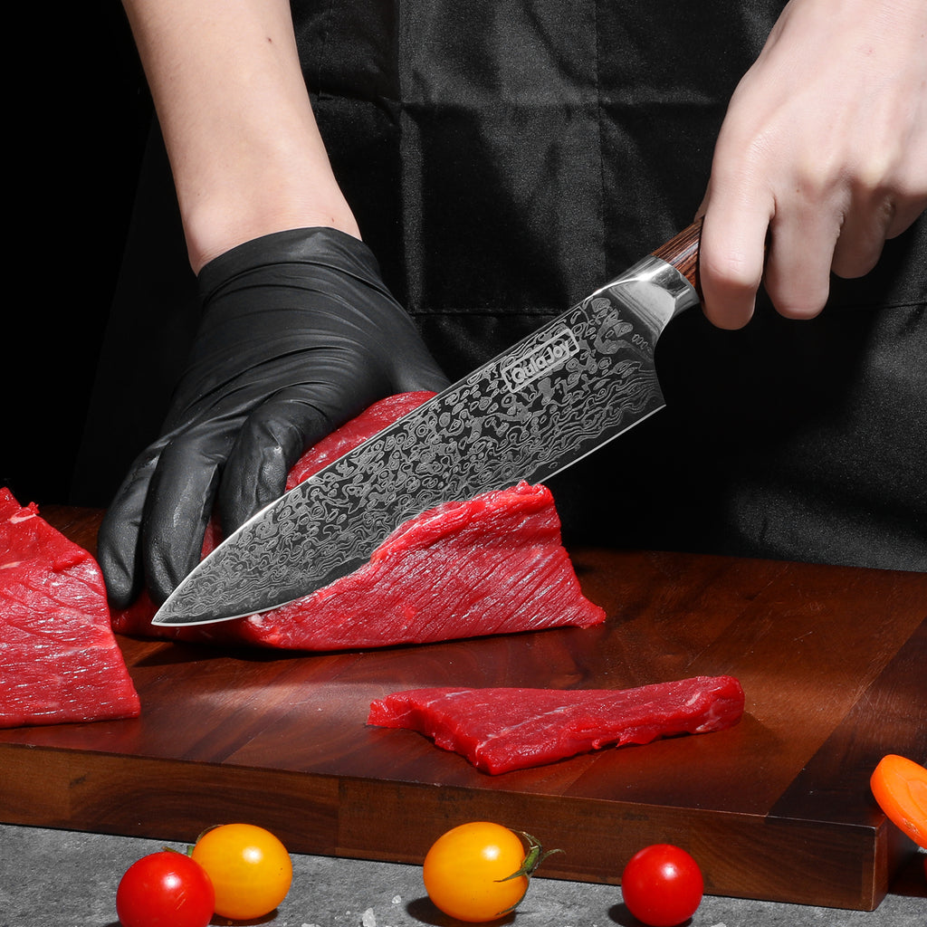 Shopi Vella German steel kitchen knife slicing raw beef on a wooden cutting board with cherry tomatoes nearby