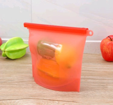 Shopi Vella silicone food storage bag in red holding fresh fruit on wooden kitchen counter