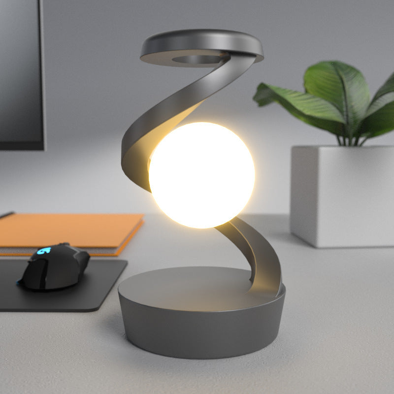 Shopi Vella rotating moon desk lamp with wireless charging on a desk with plant and mouse