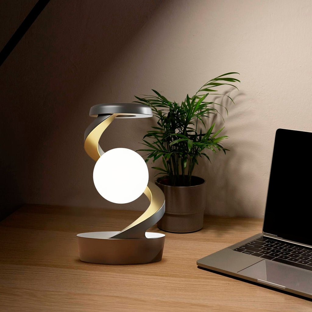 Shopi Vella rotating moon desk lamp with wireless charging on wooden desk near laptop and plant