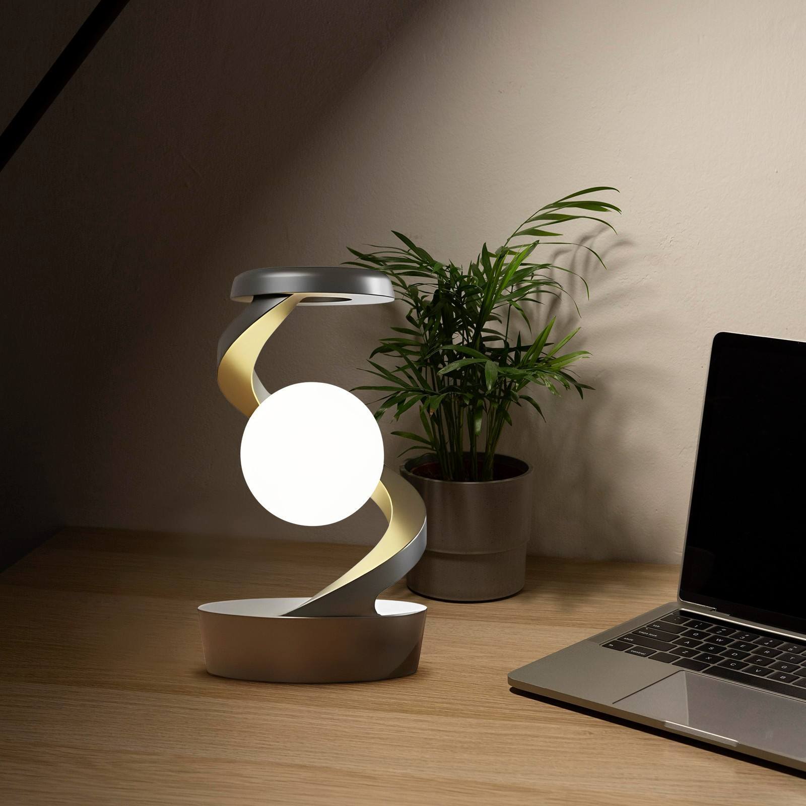 Shopi Vella rotating moon desk lamp with wireless charging on wooden desk near laptop and plant