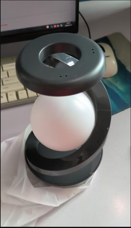 Shopi Vella rotating moon desk lamp with wireless charging featuring a modern curved black stand and glowing moon light