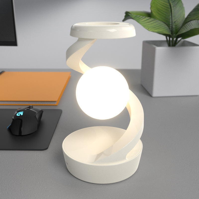 Shopi Vella rotating moon desk lamp with wireless charging in white on a gray desk