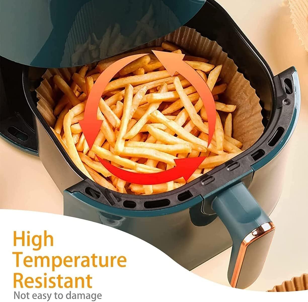 Round oil absorbing baking paper inside air fryer basket holding crispy golden french fries