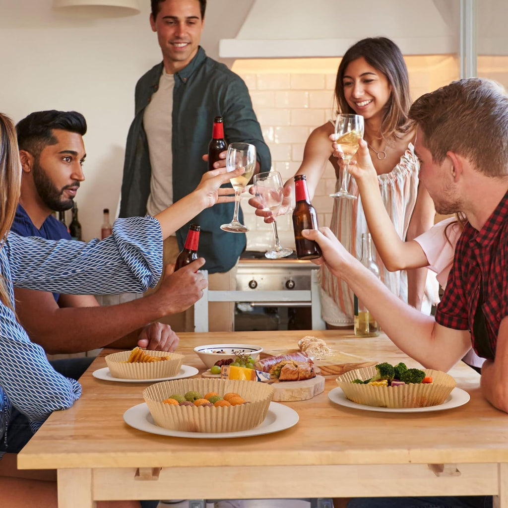 Group enjoying meal with round oil absorbing baking paper used for serving food on dinnerware
