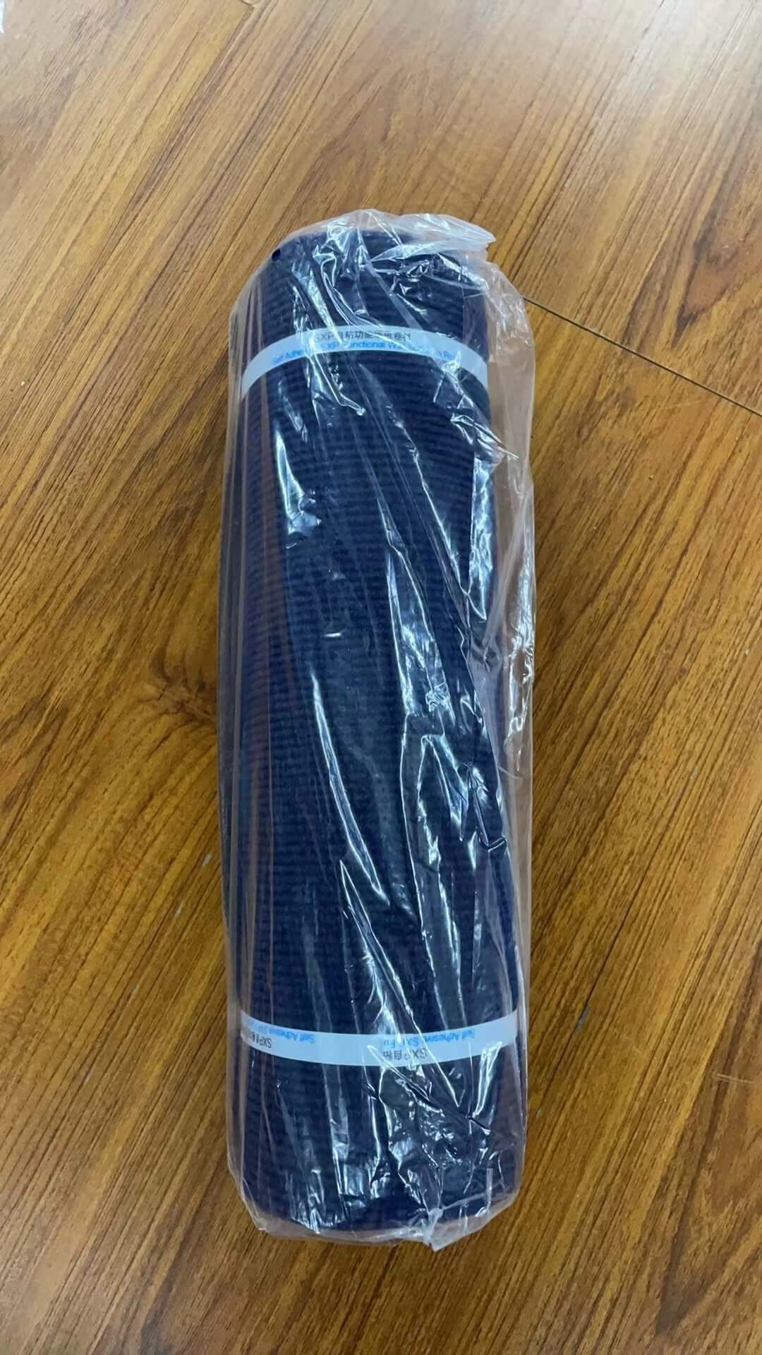 Shopi Vella self-adhesive cat scratch board rolled up in plastic packaging on wooden floor