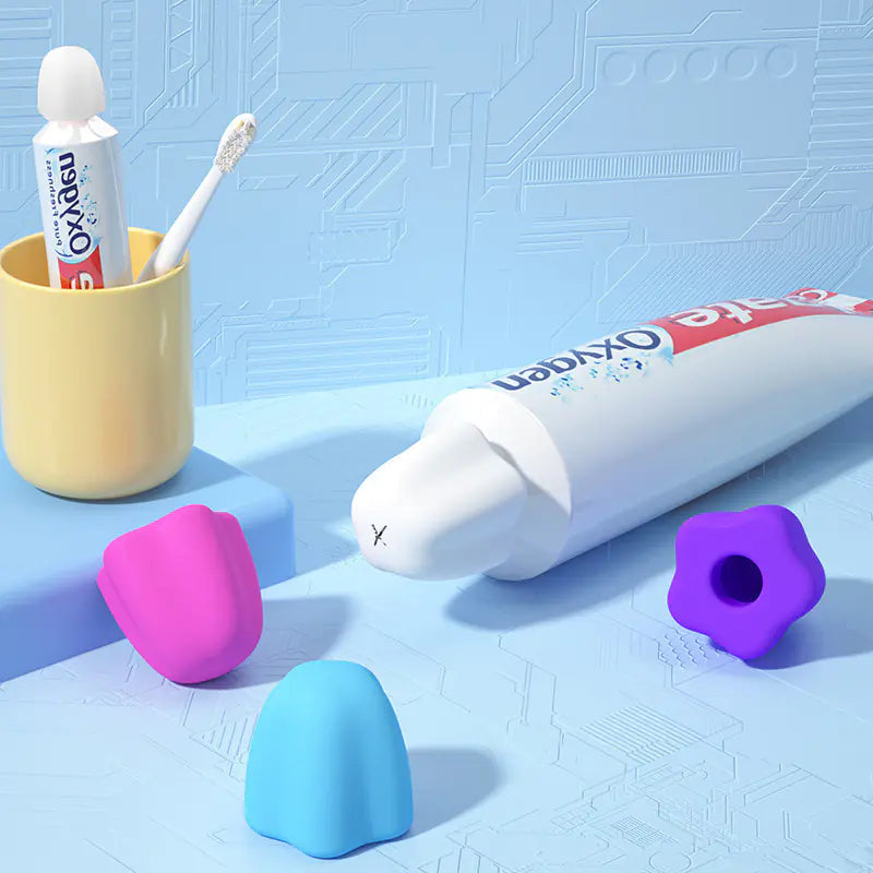 Toothpaste tube with self-sealing toothpaste cap and colorful silicone cap covers on blue surface
