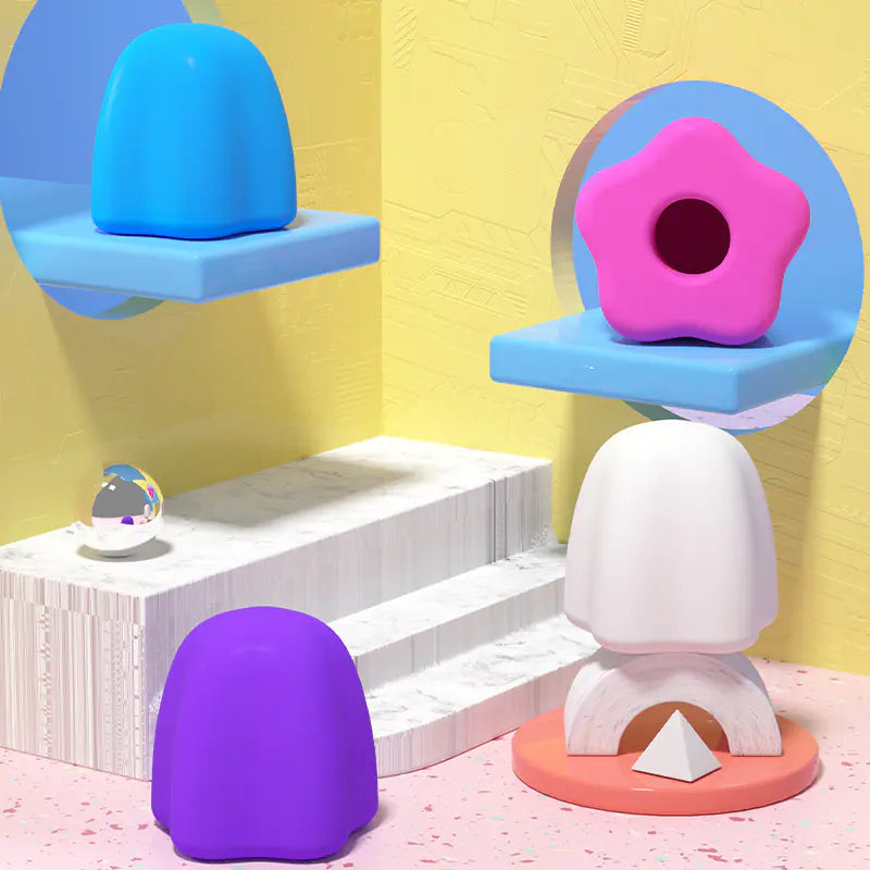 Colorful silicone self-sealing toothpaste cap prototypes displayed on geometric stands