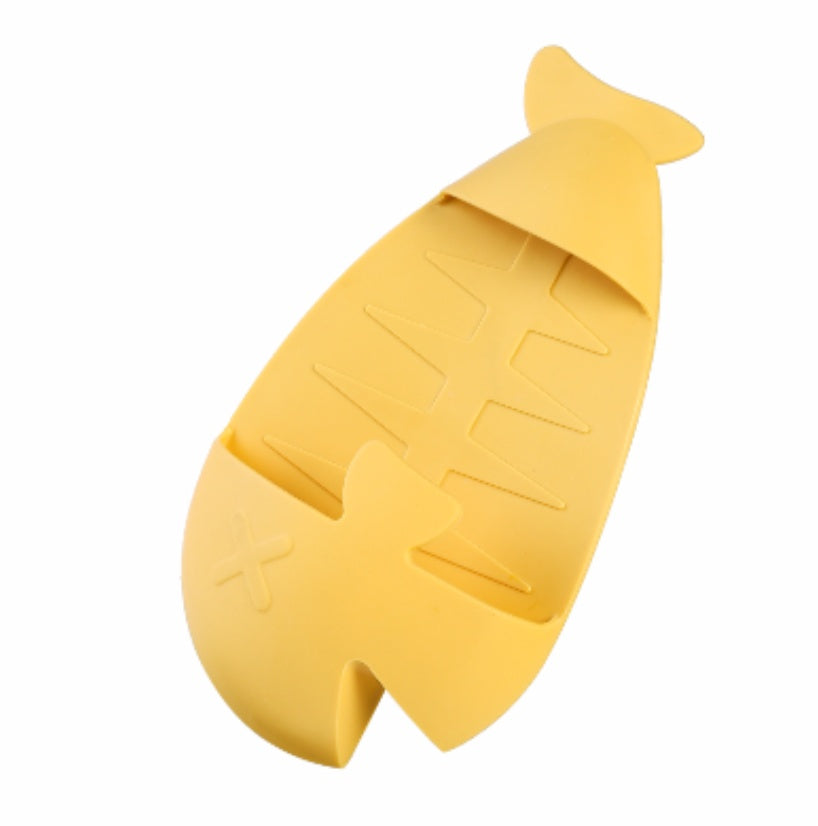 Yellow silicone floor drain with hair catcher shaped like a fish for efficient home storage
