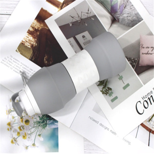 Shopi Vella gray and white silicone folding water bottle on top of open home decor magazines