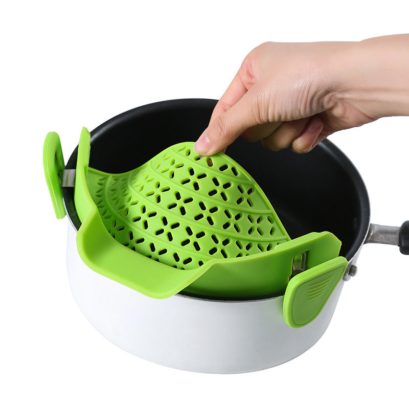 Shopi Vella green silicone pot side drain stopper clipped onto white pot for easy draining