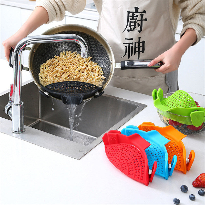 Silicone pot side drain stopper in red blocking pasta in pot for easy draining over kitchen sink
