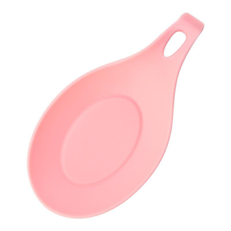 Pink silicone spoon rest for kitchen with a hole handle for easy hanging and utensil placement