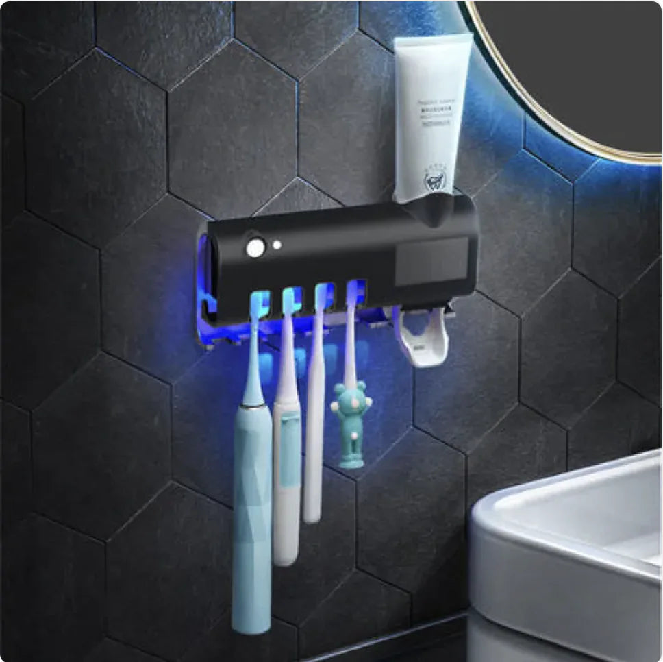 Black smart toothbrush sterilizer mounted on bathroom wall with four toothbrushes and toothpaste