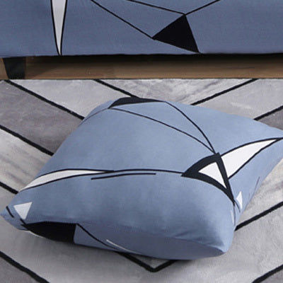 Blue sofa cushion cover floral print with geometric black and white shapes on a rug