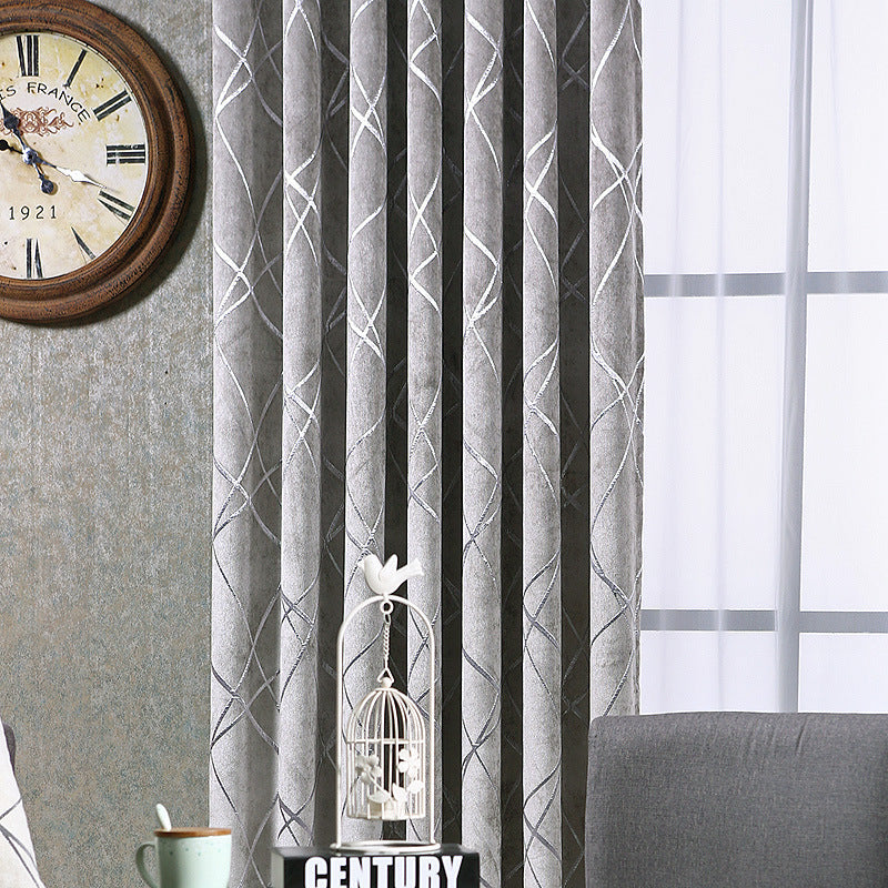 Gray patterned solid color living room curtains hanging beside a window with a clock and decorative items nearby