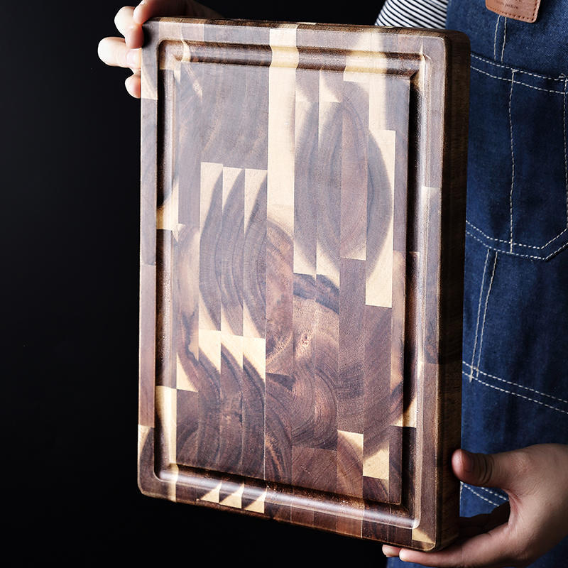 Shopi Vella solid wood cutting board with rich wood grain and juice groove held by a person