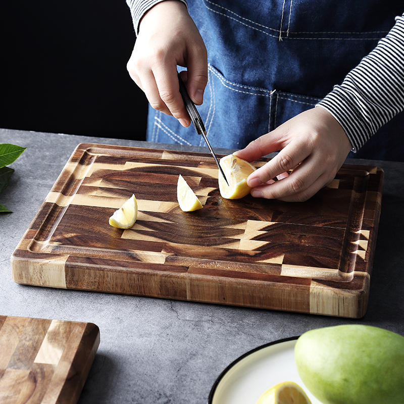 Hands cutting lemon on a solid wood cutting board with geometric pattern by Shopi Vella