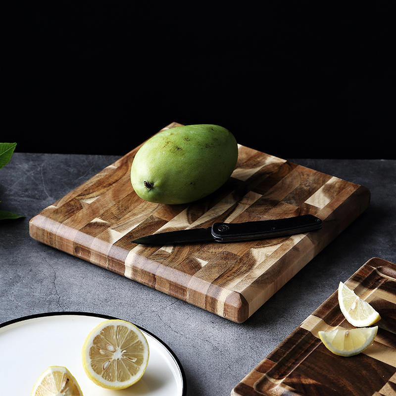 Shopi Vella solid wood cutting board with green mango and black knife on a gray surface