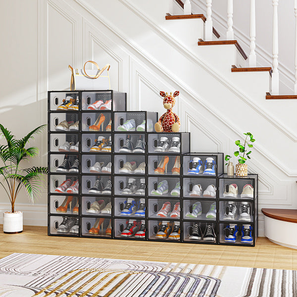 Stackable black plastic shoeboxes by Shopi Vella arranged under stairs holding various shoes