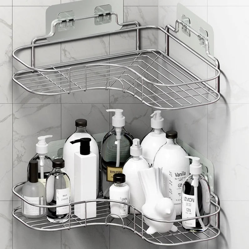 Metal corner shower caddy shelf with two tiers holding various shampoo and lotion bottles in a marble shower corner