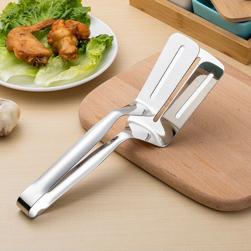 Shopi Vella stainless steel kitchen tongs resting on wooden cutting board near plate with fried chicken