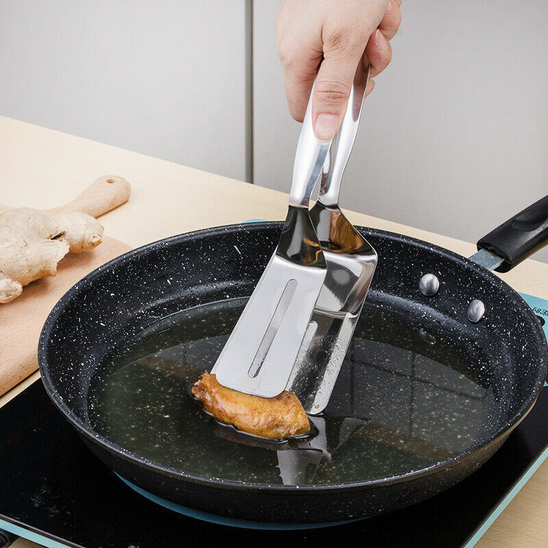 Shopi Vella stainless steel kitchen tongs holding a fried food piece over a black frying pan