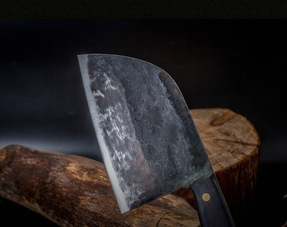 Shopi Vella stainless steel meat cleaver with a sturdy black handle on a wooden chopping block