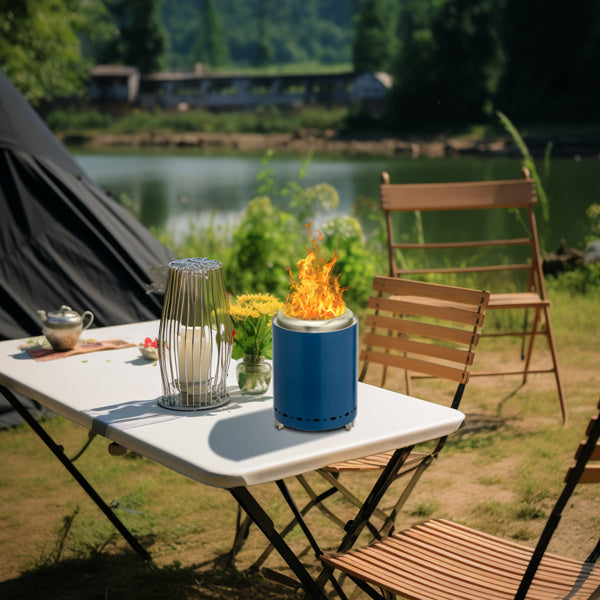 Blue stainless steel wood burning basin on a white table beside wooden chairs outdoors