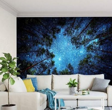 Shopi Vella bedding set with starry forest tapestry wall hanging above white sectional sofa