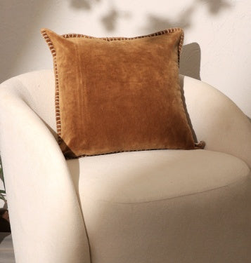 Shopi Vella stonewashed decorative pillow 19x19 in warm brown on white cushioned chair