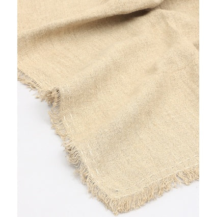 Natural beige stonewashed linen throw blanket with frayed edges for a cozy rustic look