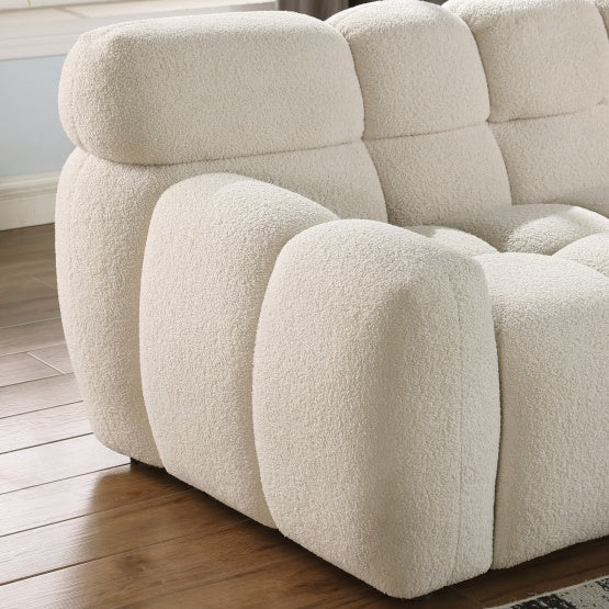 Close-up of Shopi Vella stylish apartment sofa with plush textured upholstery on wooden floor