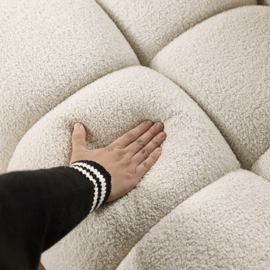 Close-up of hand pressing soft cream fabric on stylish apartment sofa by Shopi Vella