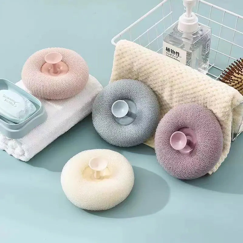 Suction bath exfoliating brush set with soft round brushes in pastel colors displayed with towels and soap