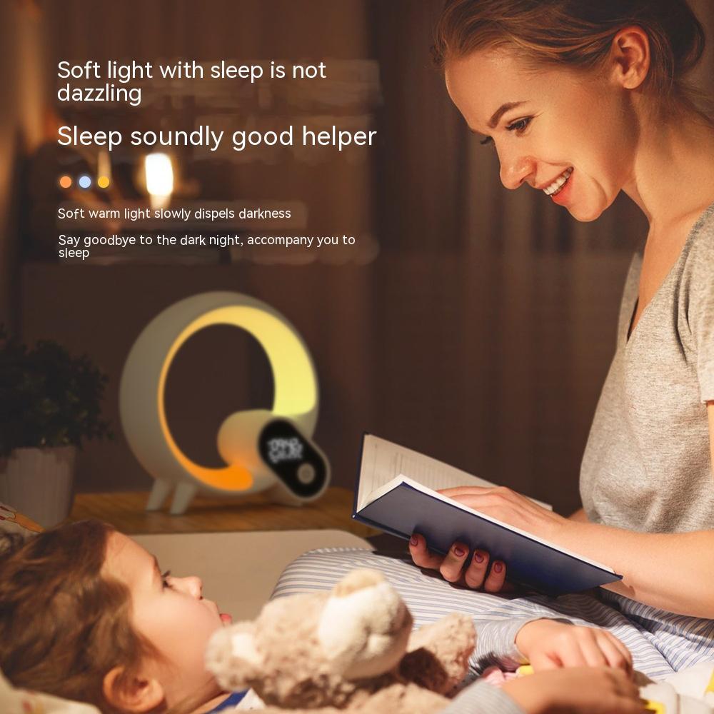 Sunrise alarm clock with Bluetooth speaker emitting soft light beside a child and mother reading a book