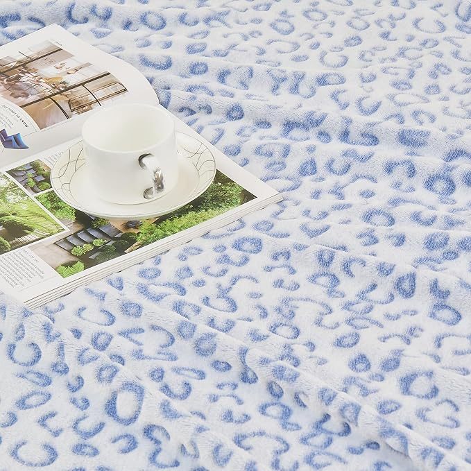 Shopi Vella super soft women's blanket with blue leopard print pattern and a cup on a magazine