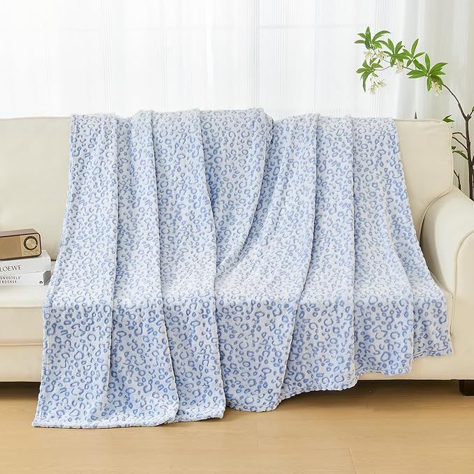 Shopi Vella super soft women's blanket in light blue leopard print draped over beige sofa